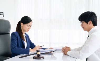 Hukuk, Danışmanlık, Anlaşma, Sözleşme, Avukat veya Avukat, elinde kalem bulunan bir müvekkille mahkemeye gitmeden önce sorulara cevap verme şeklini açıklamak üzere görüşür..