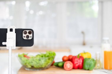 Cep telefonu kamerası ev mutfağında salata pişirme dersi videosunu kaydediyor. Gıda blogları veya vloglama, sosyal medya hobi yayıncılığı veya çevrimiçi öğrenim kursu kavramı