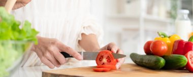 Kadın ellerinin ahşap tahtada bıçakla domatesleri doğradığı, sebze salatası pişirdiği, fotokopi alanı.