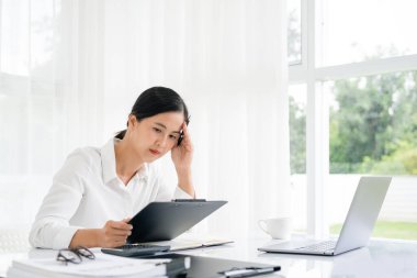 Asyalı kadınlar dizüstü bilgisayarda çalışırken streslidirler, ofiste başı ağrıyan Asyalı iş kadını, işte hasta hissederler, yer kopyalayabilirler.