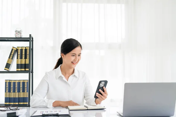 Financial businesswomen use laptop and smart phone to analyze marketing strategies and real estate data to reduce company taxes for their customers, Accounting and Tax concept.