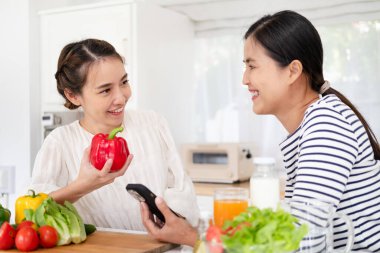 Sağlıklı Yeme Kadınlar Yemek Salatası. Güzel Gülümseyen Vegan Kızlar Mutfakta Taze Yeşil Organik Sebze Yemek için going. Fitness Yemeklerinin Tadını Çıkaran Mutlu İnsanlar. Detoks Diyet, Kilo Kaybı Beslenme Kavramı