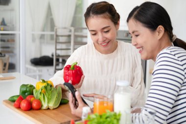 Bayan arkadaşlar vejetaryen yemeği hazırlıyorlar. Mutfakta sebze hazırlıyorlar. Arkadaşlar aşçı aşçı konsepti.