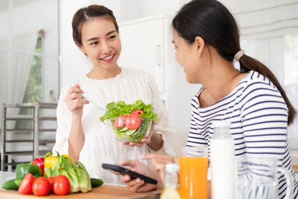 Two Asian beautiful adorable women or friends, smiling with happiness, doing activity, leisure, lifestyle for cooking, healthy food in kitchen at cozy home as hobby on weekend