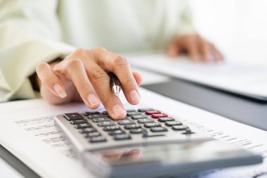 Yeniden finanse etme planları, yaşam tarzı konsepti için ipotek ev kredilerinin maliyetini gözden geçirmek ve özetlemek için hesap makinesine basan kadının yakın plan çekimi.