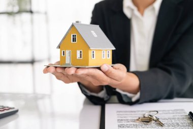 Emlakçı müşterilere örnek evler, ipotekli kredi sözleşmeleri veriyor. Kiralık bir ev alıp satmak için bir sözleşme yap. ve ev sigortası sözleşmeleri, ev kredisi konseptleri