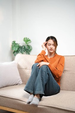 Bitkin düşmüş genç bir kadın alnına dokunuyor, koltukta tek başına oturuyor, baş ağrısı ya da migrenden muzdarip endişeli bir kız sorunları düşünüyor, boşanıyor ya da ayrılıyor, düşüncelerde kayboluyor.