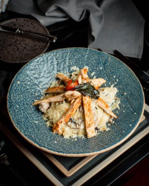 Peynir soslu makarna ile parmesan peyniri serpilmiş tavuk göğsü.