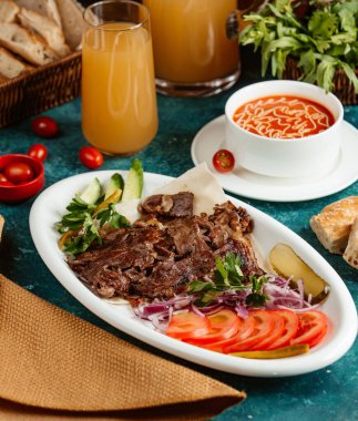 Dilimlenmiş kuzu eti, ekşi kremalı domates çorbasıyla pişirilmiş.