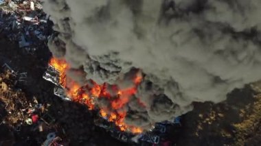 Yangın, araba hurdalığında büyük bir yangın, kara duman atmosferi kirletiyor, ekolojik felaket, küresel ısınma sorunu. Yüksek kalite 4k görüntü