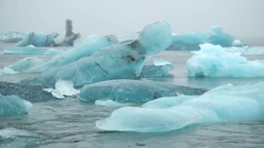 Mavi buzdağının sisli buzul gölünde, saf İzlanda doğası. Kışın ve buzun kuzeyindeki güzel doğal mucize. 8k 4:2:2 10 bit.