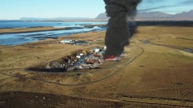 Yangın, araba hurdalığında büyük bir yangın, kara duman atmosferi kirletiyor, ekolojik felaket, küresel ısınma sorunu. Yüksek kalite 4k görüntü