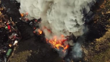 Yangın, araba hurdalığında büyük bir yangın, kara duman atmosferi kirletiyor, ekolojik felaket, küresel ısınma sorunu. Yüksek kalite 4k görüntü