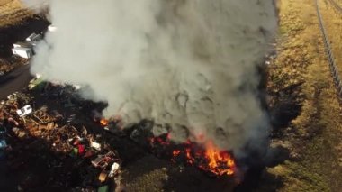 Yangın, araba hurdalığında büyük bir yangın, kara duman atmosferi kirletiyor, ekolojik felaket, küresel ısınma sorunu. Yüksek kalite 4k görüntü