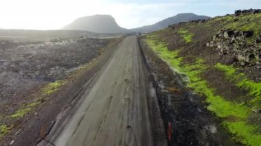 İzlanda 'da yol manzarası, güneşli havada güzel volkanik doğa, varış noktası çakıl yol. Yüksek kalite 4k görüntü