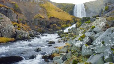 8K 7680x4320. İzlanda 'da şelale, sonbahar mevsiminde dağ nehri, güzel doğa volkanik manzarası. Yüksek çözünürlüklü sinematik UHD 4320p.