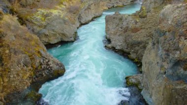 Saf Turkuaz Buzul Suyu ile Canyon Nehri İzlanda 'da sıra dışı dağ doğası manzarası. Çekim 8K Çözüm 4320p.