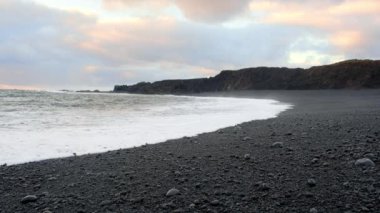 İzlanda 'nın Günbatımında Kara Kum Sahili, Mavi Kuzey Atlantik Okyanusu Suyu ile Volkanik Kayalık, 4320 Peni Kararında Vuruldu.