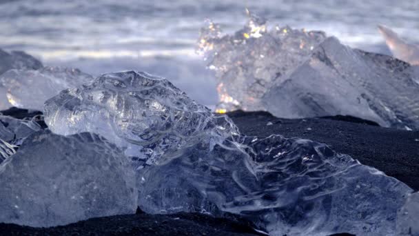Παγόβουνα Έλαμπαν Μαύρη Ηφαιστειακή Άμμο Στο Ηλιοβασίλεμα Clear Ice Chunk — Αρχείο Βίντεο