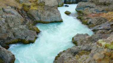 Saf Turkuaz Buzul Suyu ile Canyon Nehri İzlanda 'da sıra dışı dağ doğası manzarası. Çekim 8K Çözüm 4320p.