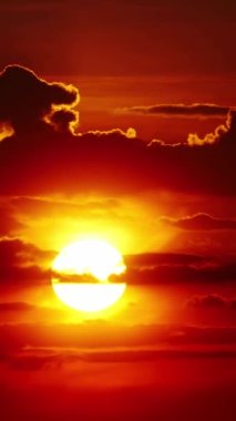 Vertical Screen: Sunset or Sunrise in the Yellow Sky. Big Bright Sun Moves in Sky. Awesome Time Lapse Landscape of Sky and Clouds with Amazing Colours. Vibrant Warm Color. Shot for Social Media.