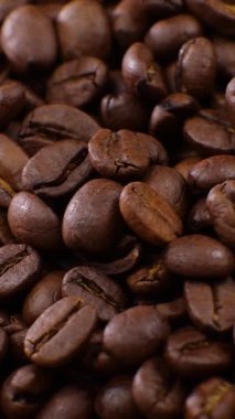 Vertical screen: Roasted vietnamese coffee bean. Fragrant coffee beans scrolls slowly around the camera. Slow Motion Close Up of Whole Roasted Coffee Beans.High angle view. Shot for Social Media. High