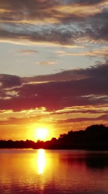 Vertical Screen: Sunset or Sunrise in the Yellow Sky. Big Bright Sun Moves in Sky. Awesome Time Lapse Landscape of Sky and Clouds with Amazing Colours. Vibrant Warm Color. Shot for Social Media.