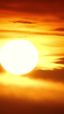 Vertical Screen: Sunset or Sunrise in the Yellow Sky. Big Bright Sun Moves in Sky. Awesome Time Lapse Landscape of Sky and Clouds with Amazing Colours. Vibrant Warm Color. Shot for Social Media.