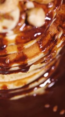 Vertical Screen: Sweet pancakes with chocolate syrup. Healthy grilled food cooked at home. Delicious Breakfast Food with Bananas and Chocolate. Shot for Social Media. High quality footage