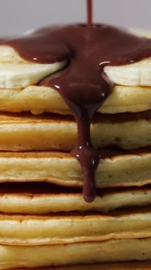 Vertical Screen: Sweet pancakes with chocolate syrup. Healthy grilled food cooked at home. Delicious Breakfast Food with Bananas and Chocolate. Shot for Social Media. High quality footage