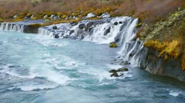 Autumn Waterfall in Iceland. Pure Turquoise Water in Mountain River. Popular Tourist Spot. Famous Travel Destination. Beautiful Nature, Unusual Landscape. Footage Shot in 8K Resolution 4320p.