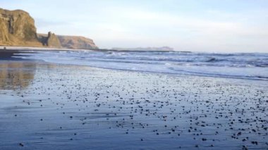 Sea Waves on the Black Volcanic Beach Close Up. Clean Coast with Black Volcanic Sand in Iceland. Calm Ocean Water in Sunny Weather. Vik, Iceland. Shot with Slider in 8k Resolution. High quality 4k 