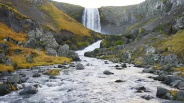 Autumn Waterfall in Iceland. Pure Turquoise Water in Mountain River. Popular Tourist Spot. Famous Travel Destination. Beautiful Nature, Unusual Landscape. Footage Shot in 8K Resolution 4320p.