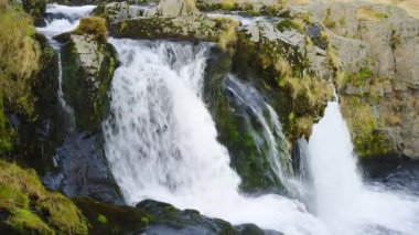 Autumn Waterfall in Iceland. Pure Turquoise Water in Mountain River. Popular Tourist Spot. Famous Travel Destination. Beautiful Nature, Unusual Landscape. Footage Shot in 8K Resolution 4320p.