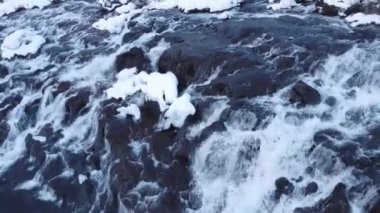 Hraunfossar, Famous Waterfall in Iceland, Snowy Ice Mountain River in Winter, Magical Outdoor Winter Time Location, Pure Glacial Water with a Huge Current. Clear Scenic Landscape Aerial View.