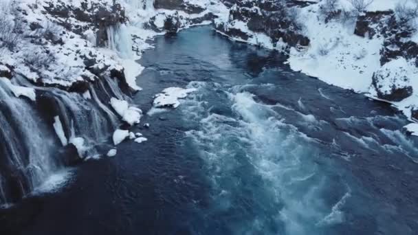 Hraunfossar 冰岛著名的瀑布 冬天的雪山河 神奇的户外冬季位置 带有巨大电流的纯净冰川水 清晰的风景及空中景观 — 图库视频影像