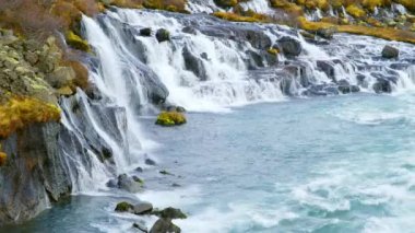 Autumn Waterfall in Iceland. Pure Turquoise Water in Mountain River. Popular Tourist Spot. Famous Travel Destination. Beautiful Nature, Unusual Landscape. Footage Shot in 8K Resolution 4320p.
