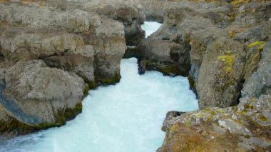 Saf Turkuaz Buzul Suyu ile Canyon Nehri İzlanda 'da sıra dışı dağ doğası manzarası. Çekim 8K Çözüm 4320p.