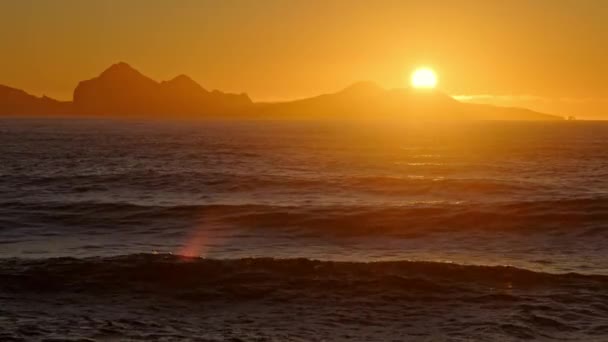 太阳升起在风暴的海面上 在日落时闪耀着金色的浪花 在冰岛的山脉海岸上空闪耀着迷人的光芒 阳光下美丽的日出和平静的天气 以8K解像度射击 — 图库视频影像