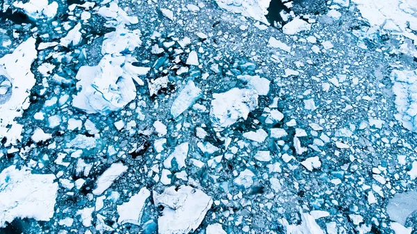 Melting Arctic Ice in Ocean Water. Blue Glacier Ice Covered with Snow in Iceland. Climate Crisis. High quality photo