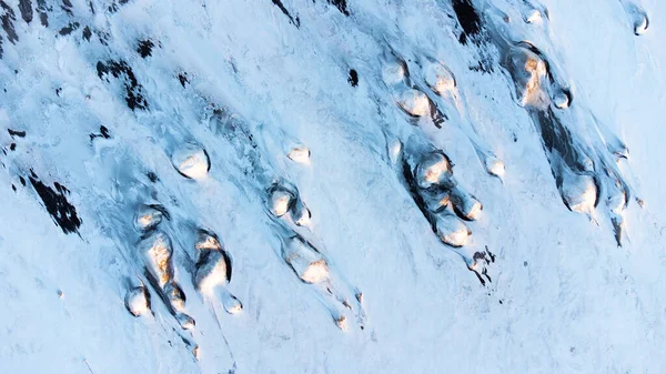 Winter Iceland Landscape at Sunrise. Unusual Snow Covered Hills On The Ocean Shore. Beautiful Abstract Aerial View. Popular Tourist Destination. Travel Europe.