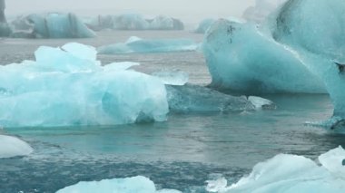 Blue Iceberg in Foggy Glacier Lagoon, Pure Nature in Iceland. Beautiful Natural Miracle in North Country. Ancient Blue Ice Is Melting Due To Global Warming. Winter and Ice Concept. Shot in 8k.