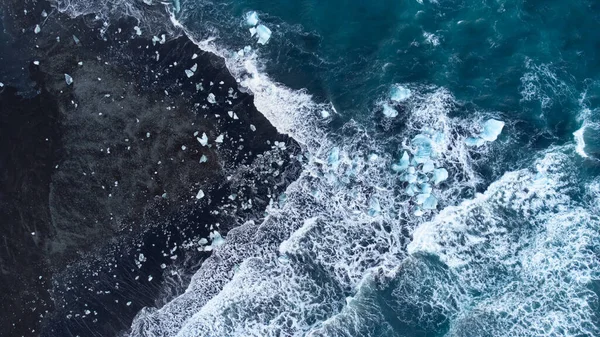Pure Blue Glacier Ice on Black Sand Beach. Turquoise Sea Water. Diamond Beach in Iceland. High quality photo
