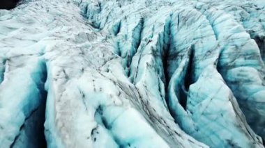 Large Glacier in Sunny Winter Day. Beautiful Nature Landscape In Iceland. Pure Blue Ice with Volcanic Ash. Melting Glaciers And The Environment Problem. Aerial View. High quality 4k footage