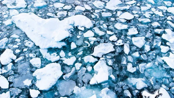 Melting Arctic Ice in Ocean Water. Blue Glacier Ice Covered with Snow in Iceland. Climate Crisis. High quality photo