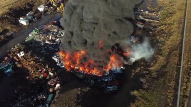 Yangın, araba hurdalığında büyük bir yangın, kara duman atmosferi kirletiyor, ekolojik felaket, küresel ısınma sorunu. Yüksek kalite 4k görüntü