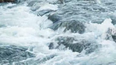 Taş kayaların arasından akan saf su akıntısı. Yaz Günü 'nde Vahşi Dağ Nehri Suyun Sıçrıyor. İzlanda. 8K 'da çekilmiş..