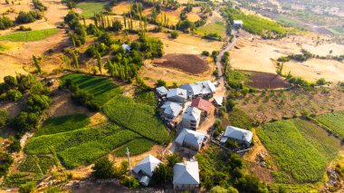 Small quiet village in Turkey. Farming and beautiful landscape with colorful fields and trees. Traditional Settlement at sunrise. Aerial view. High quality photo