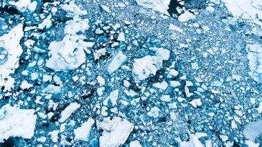Melting Arctic ice in ocean water. Blue glacier ice covered with snow in Iceland. Global warming and climate crisis. Pure antarctic landscape aerial view.. High quality photo