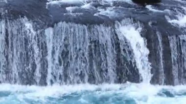 Wild mountain river flowing through stone boulders. Clear stream in Iceland close up. Huge cascade from rocks in national park. Water background concept. Shot in 8k resolution